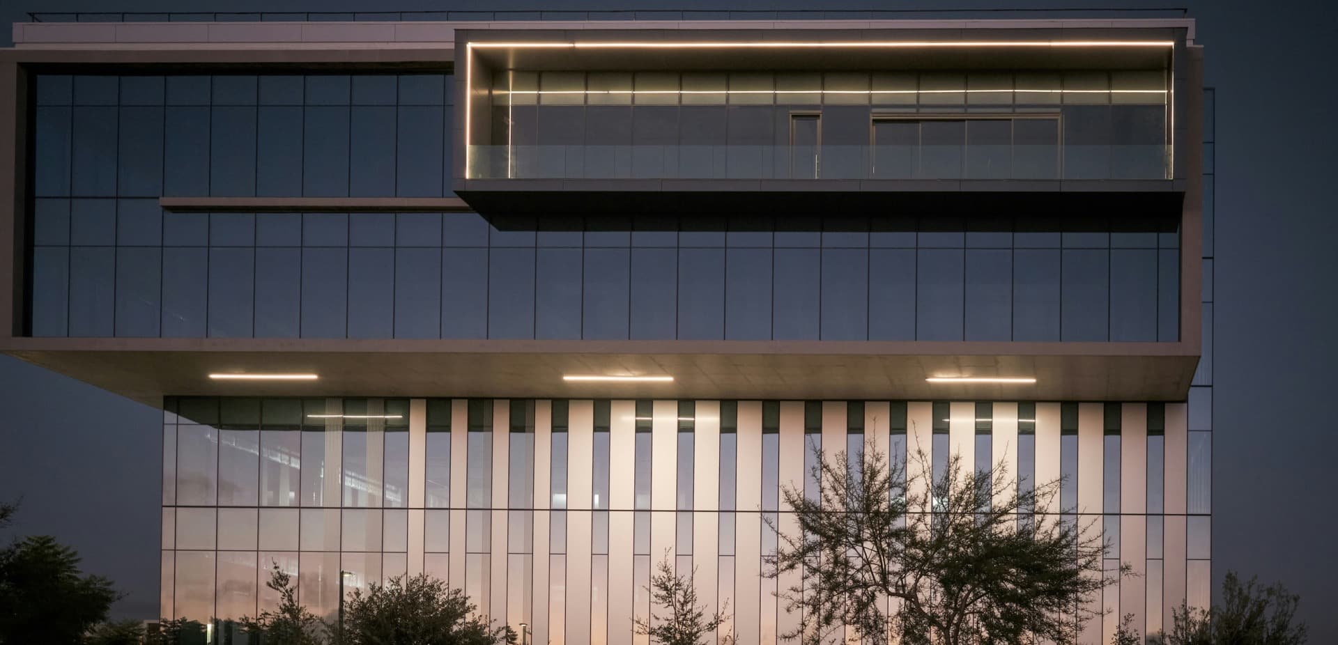 Corporate glass building facade at dusk